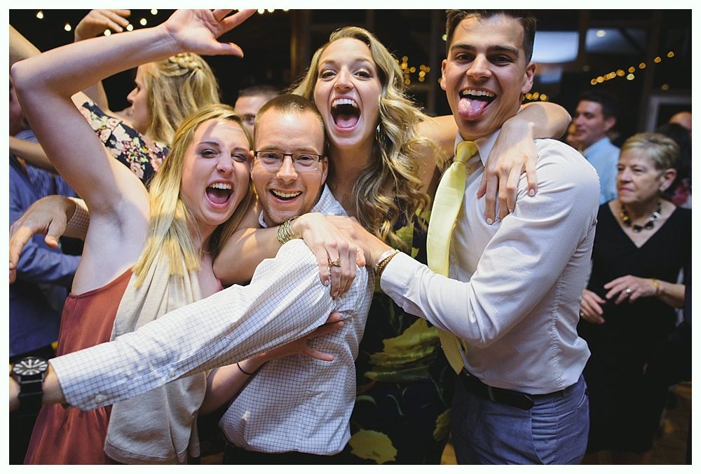 People dancing at a party: a singer with a microphone and a woman singing with arms outstretched. Blue lighting.