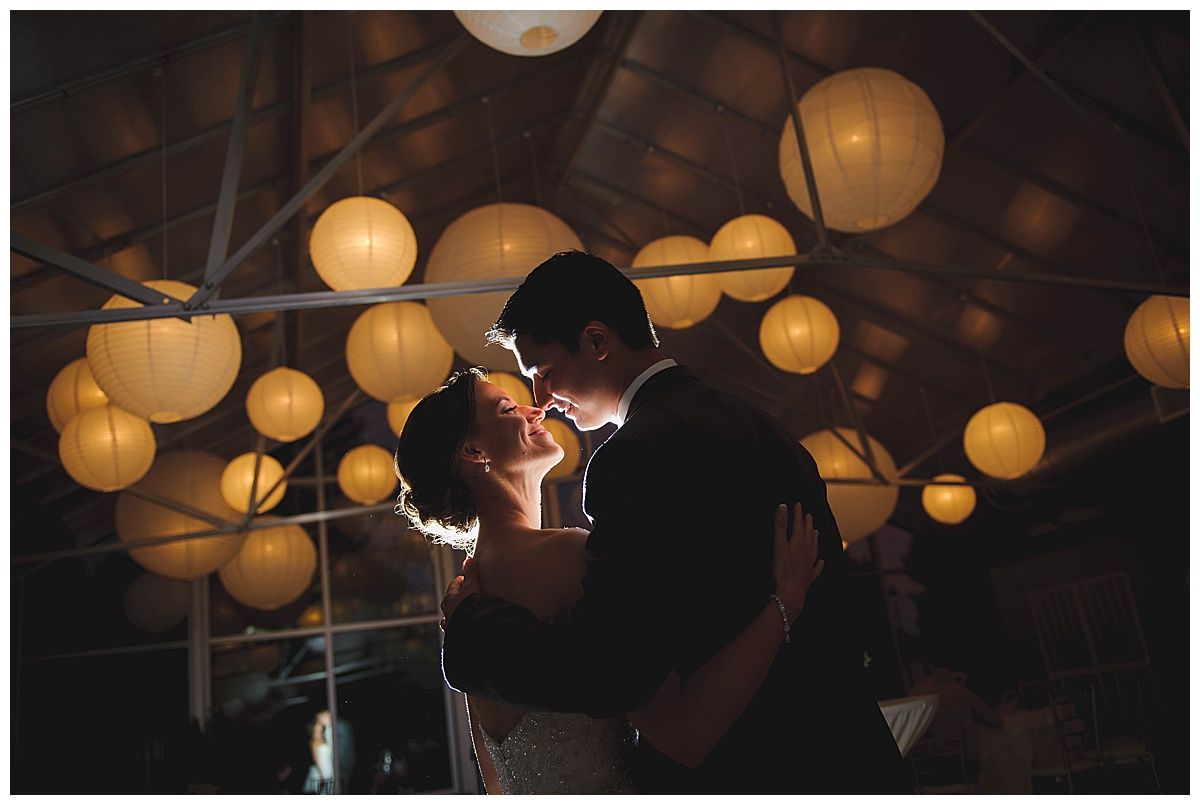 Couple embracing under glowing paper lanterns.