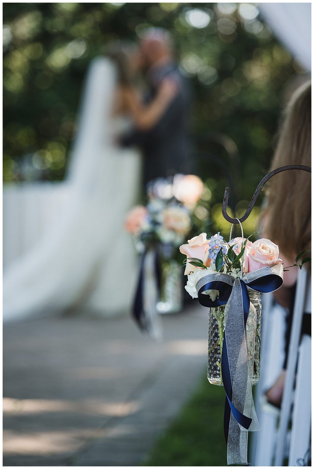Wedding ceremony decorations with a blurred couple kissing in the background.