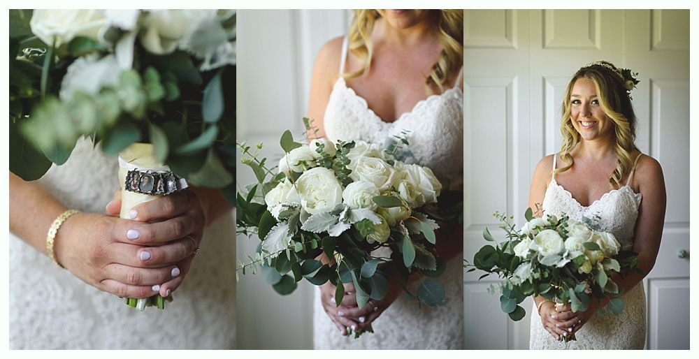 Bride in a white dress holding a bouquet of white flowers and greenery, smiling.