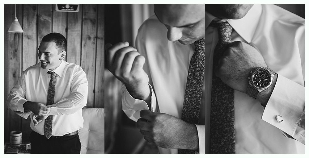 Man adjusting shirt cuffs, wearing tie and watch, getting ready indoors.