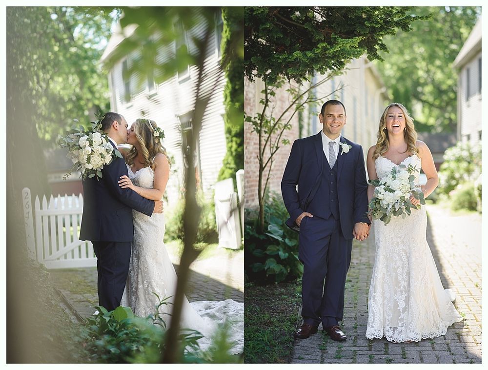 Wedding couple, hugging and kissing in front of a white picket fence, then walking and smiling on a brick path; sunny outdoor setting.
