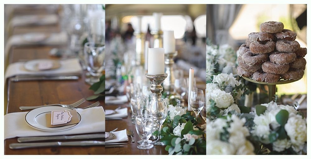 Formal table setting with candles, flowers, and a stack of donuts.