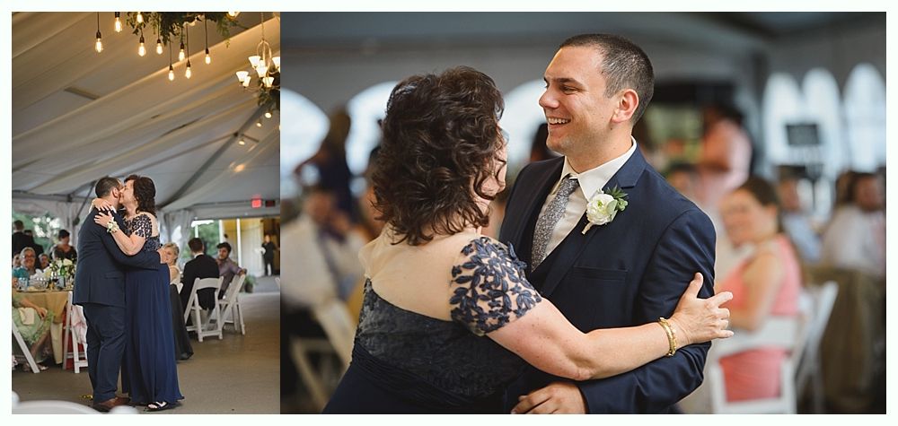 Wedding reception: A man in a suit dances with a woman in a dark dress, smiling. Tent with lights in the background.