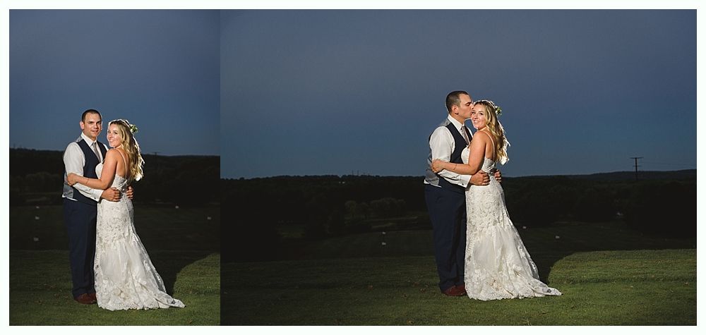 Newlyweds embrace outdoors at dusk; the man kisses the woman's cheek.