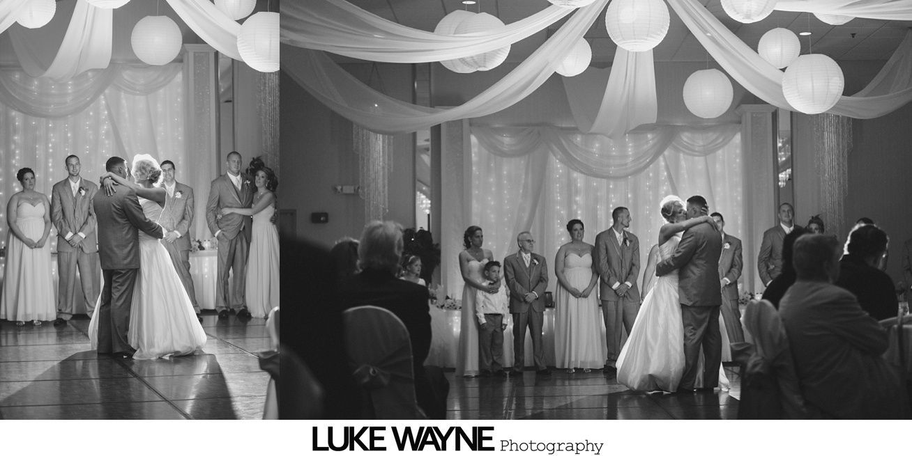Wedding reception with couples dancing, wedding party, and guests. Ballroom setting with white decor.