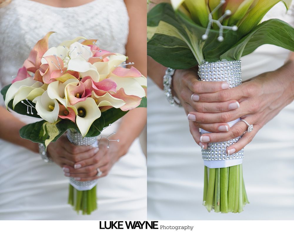 Bride holding a bouquet of calla lilies, with a rhinestone-wrapped handle, wearing a white dress and ring.