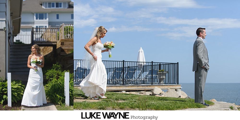 Bride approaching groom, seaside ceremony. Bride in white dress, groom in gray suit, sunny day.