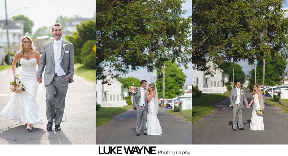 Bride and groom walking in street; woman in white dress, man in gray suit. Outdoors, day.