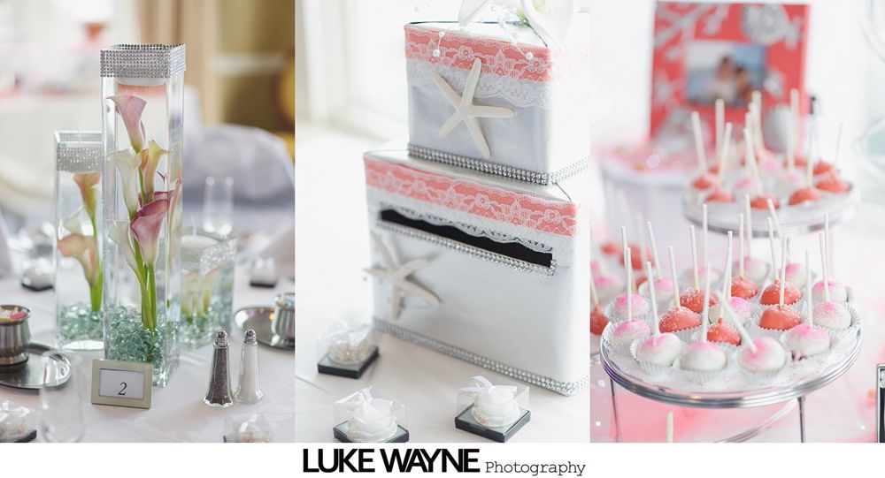 Wedding reception decor: floral centerpiece, two-tiered cake with starfish, and cake pops, all in shades of coral and white.