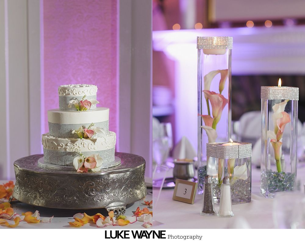 Wedding cake on silver stand, table with calla lilies and candles.