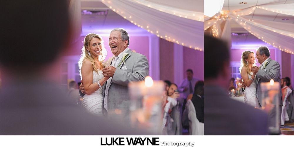 Bride and father dancing at a wedding reception; room decorated with lights; candlelit tables.