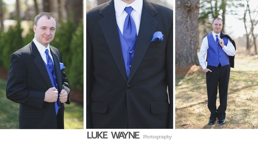 Man in black suit and cobalt blue tie, vest, and pocket square, outdoors.