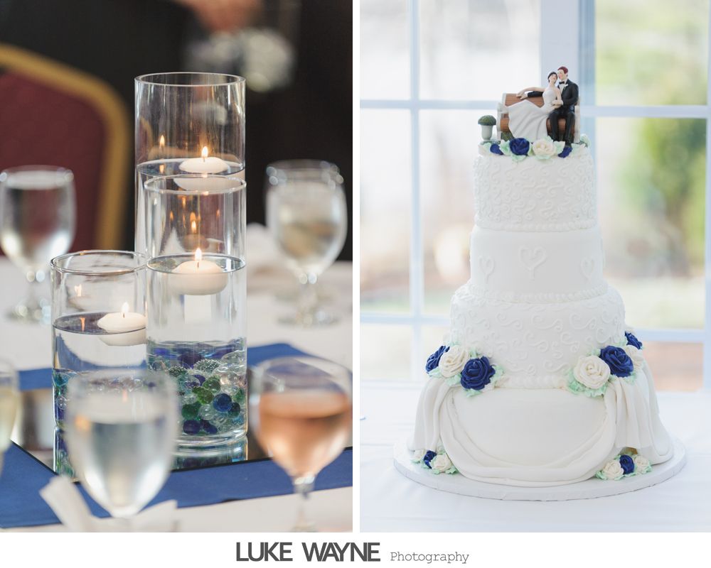 Table centerpiece with floating candles and wedding cake with couple figurine and blue flowers.
