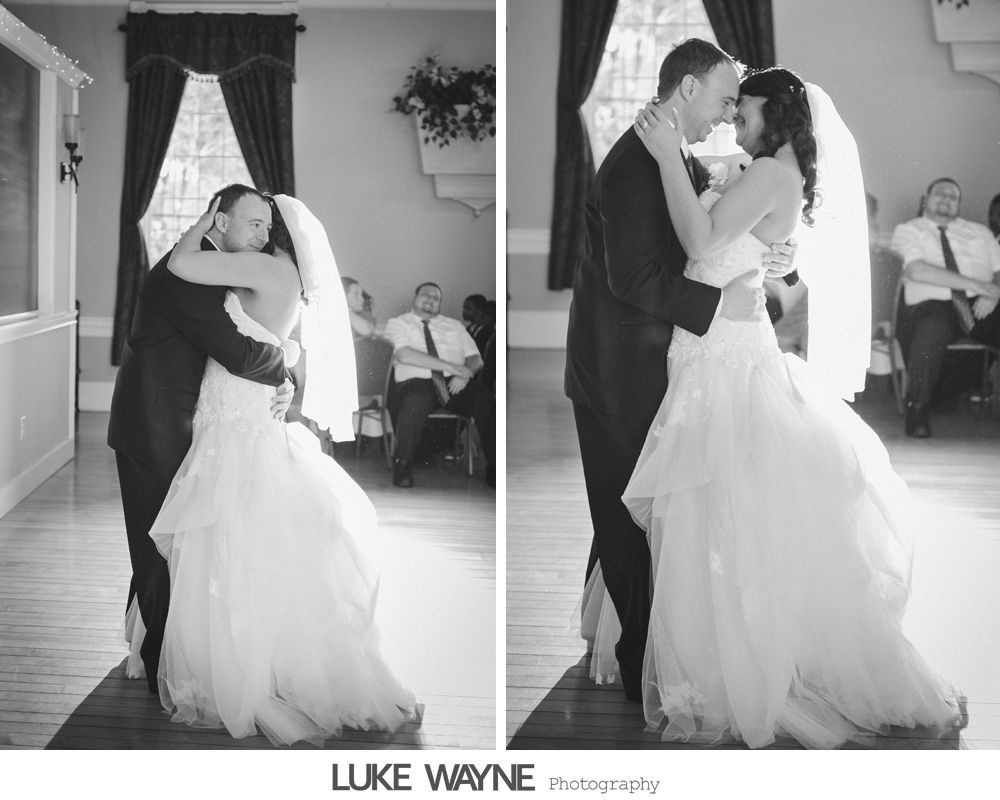Bride and groom share a dance at their wedding reception. Black and white photo.