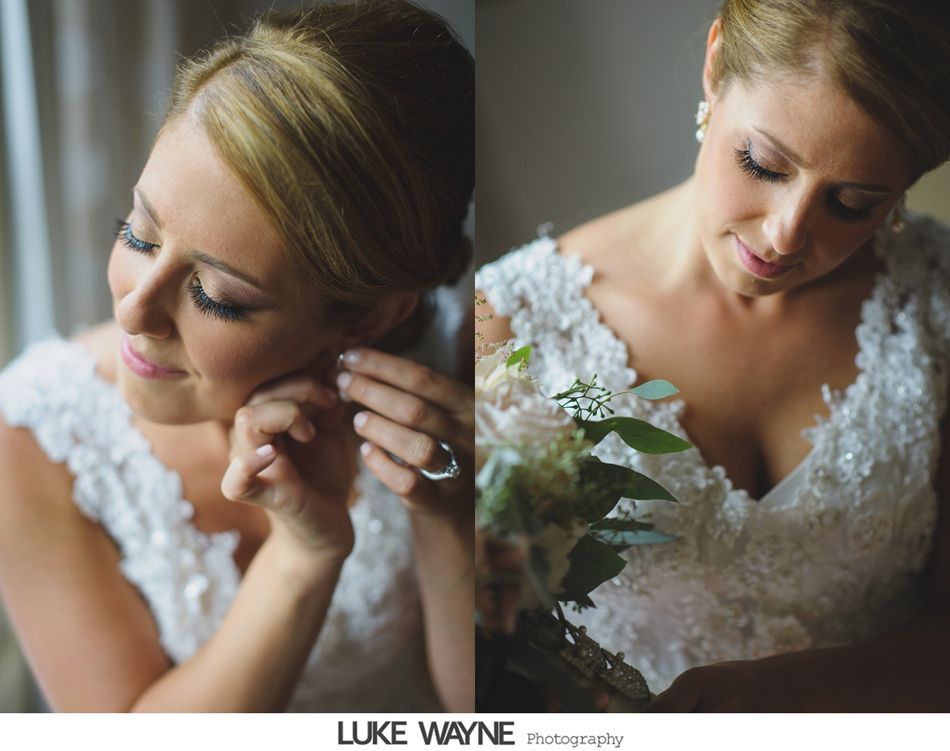 Bride putting on earring, wearing a white lace dress and holding a bouquet.