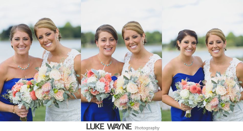 Bridesmaids and bride pose outdoors near water, wearing blue and white dresses, holding bouquets and smiling.