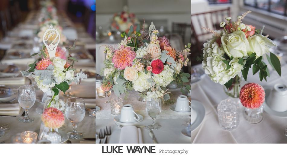 Wedding table centerpieces: floral arrangements with white, peach, and coral blooms, set on a long table with place settings.