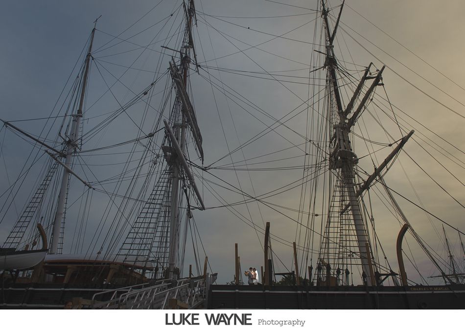 Tall ship masts and rigging against a cloudy sky.