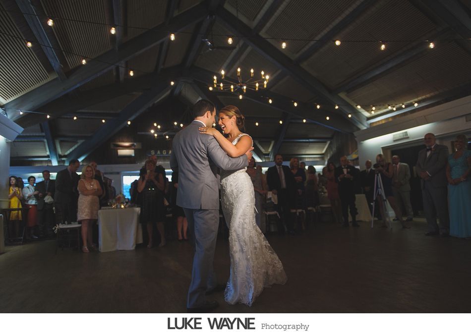 Couple dancing at a wedding reception under string lights.