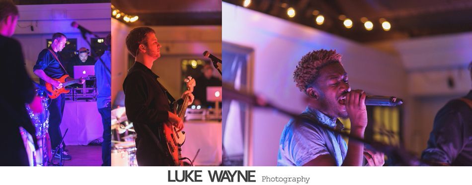 Band performing at an event, lit by colorful lights. Musicians play instruments, singer sings into a microphone.