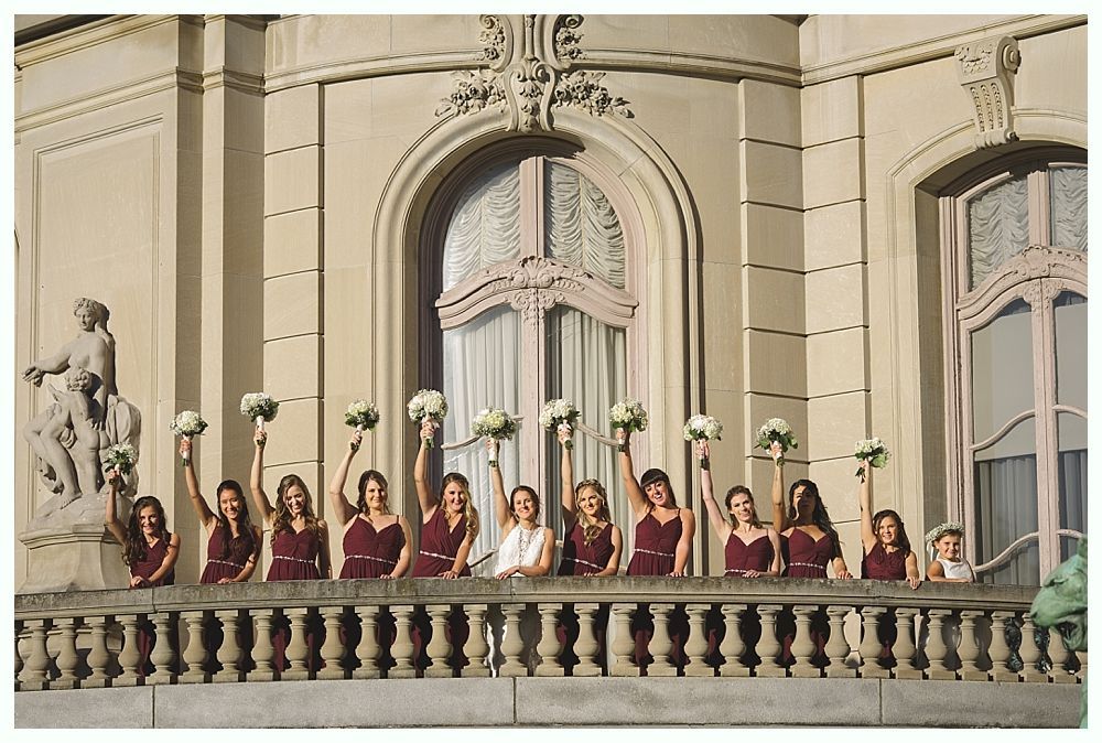 Newlyweds exiting outdoor wedding ceremony, holding hands, smiling. Wedding party applauds.