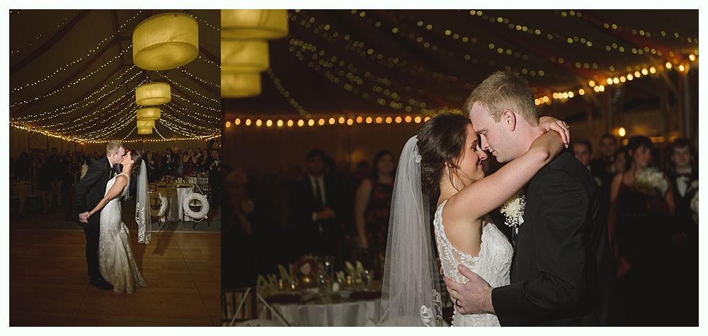Wedding cake with figurines, on a wood slice. Rustic decor with blurred lights in the background.