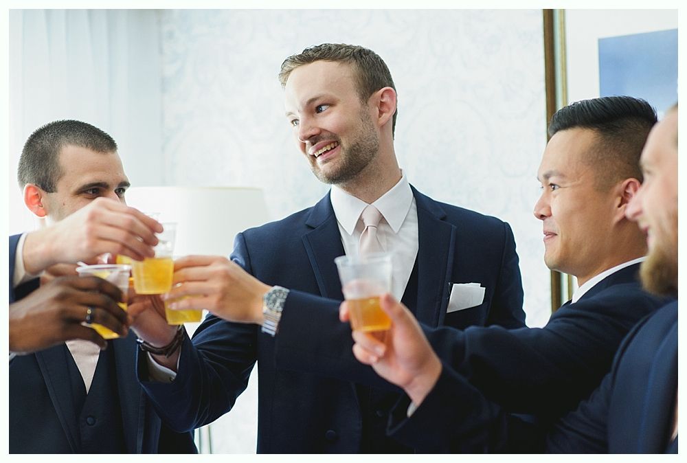 Men in suits toasting with drinks.