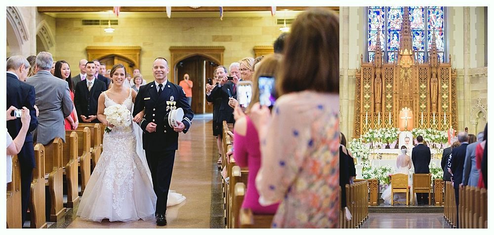 Bride and father walk down aisle during a wedding ceremony. Guests watch; one photographs. Elaborate altar in background.