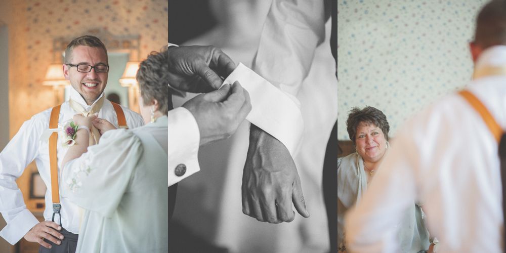 Bride and groom kissing amidst trees, holding bouquets. Black and white photo.