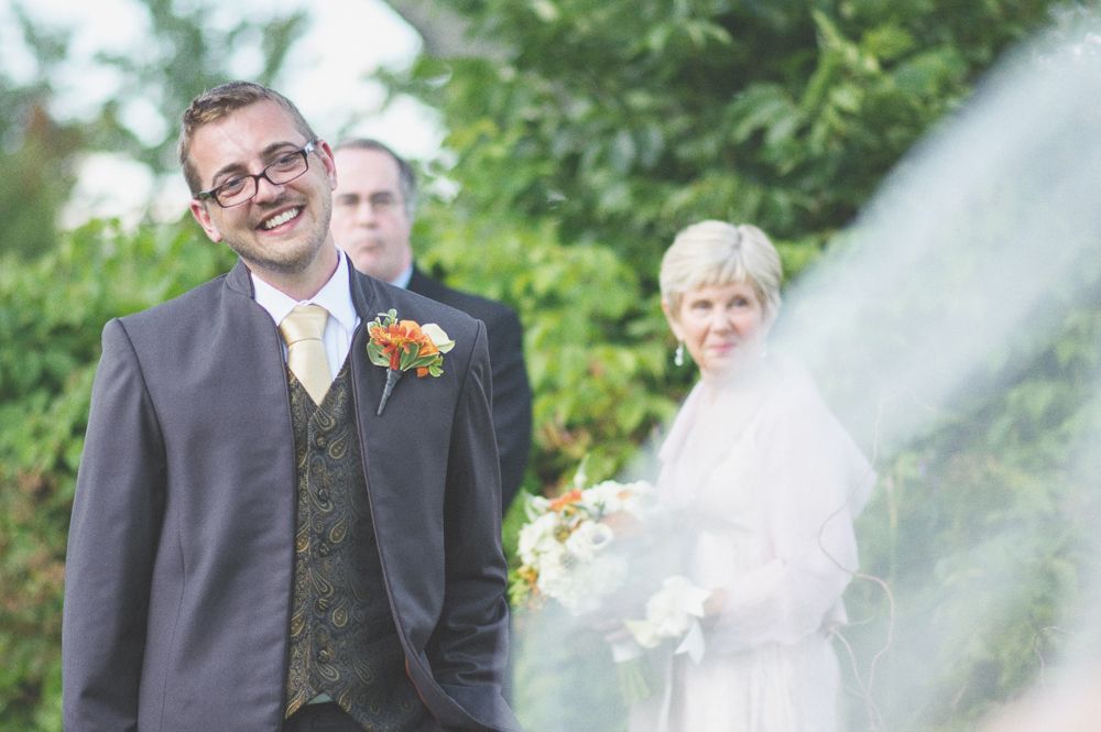 Wedding ceremony: couple at the altar, guests watching. Outdoor setting.