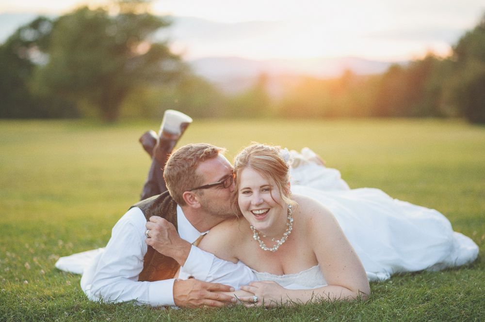 Wedding couple embraces, lit by bright flash. Stairs in background. Black and white.