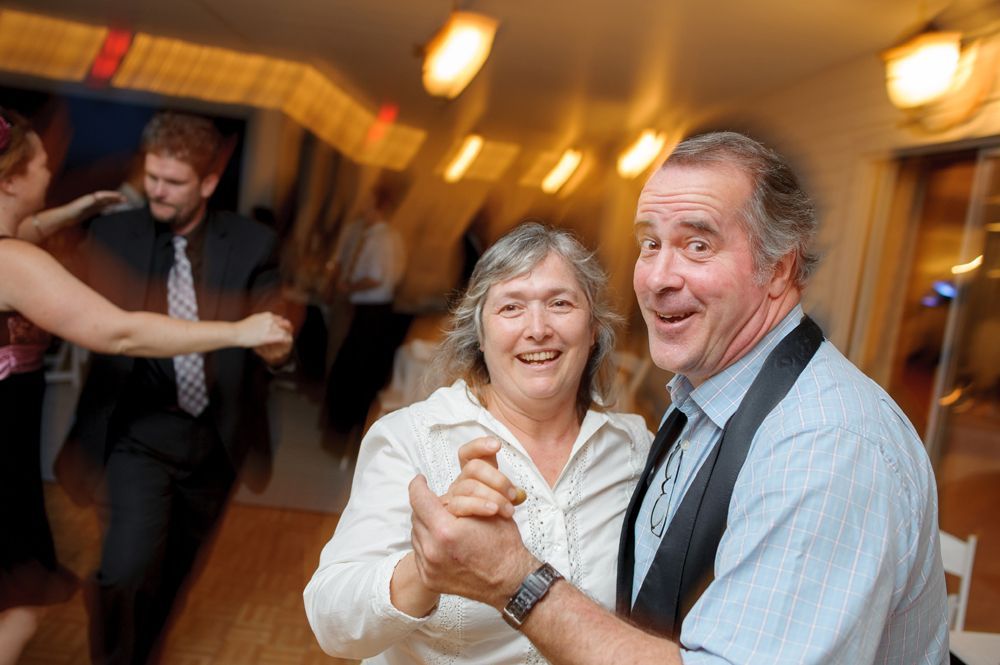 Person taking photo in mirror, indoors; black and white.