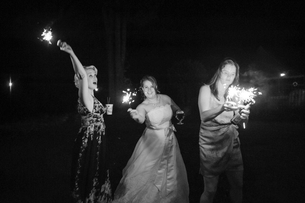 Person taking photo in mirror, indoors; black and white.