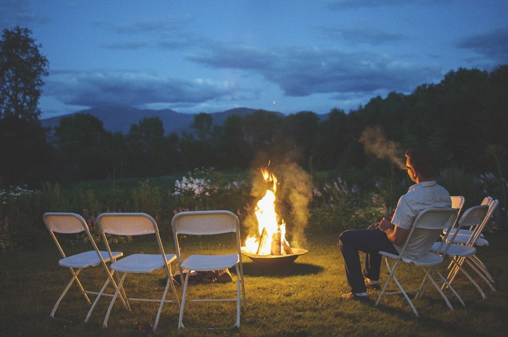 Bride facing camera, blurred. Two women, one smiling, one on phone, observe in a room.