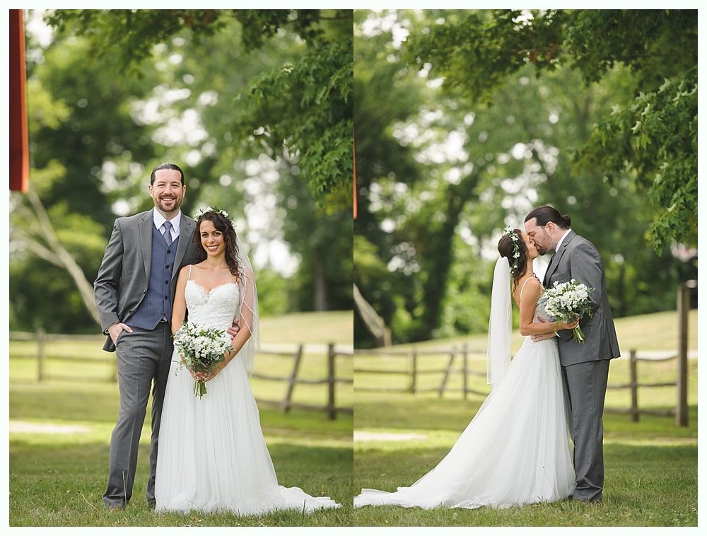 Bride and groom outdoors. The couple poses in front of a wooden fence. The groom kisses the bride.