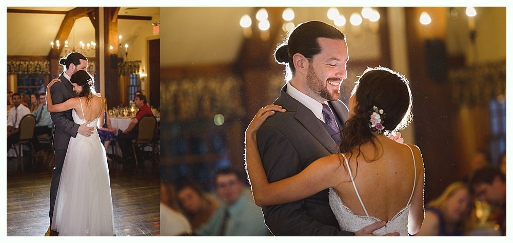 Couple dancing at a wedding reception, she in a white dress, he in a suit, both smiling.