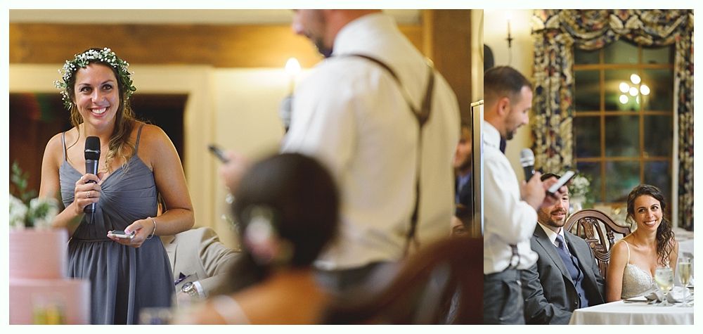 People at a wedding reception giving speeches. Woman in a blue dress with a floral crown smiles.