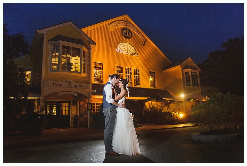 Couple embracing in front of a warmly lit building at night.