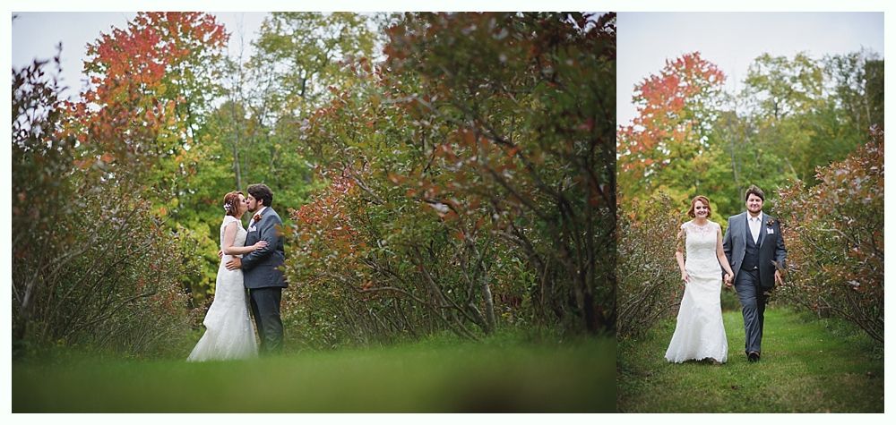 Wedding couple kissing and walking outdoors in front of a tree with red and green leaves.