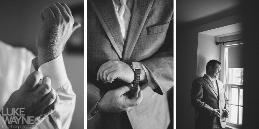 Man in suit getting ready, adjusting sleeves, watch, and looking out window. Black and white.