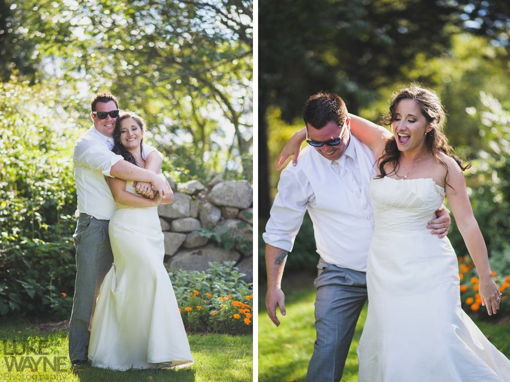 Bride and groom embracing in a garden, with varied expressions, sunny day, formal attire, surrounded by greenery.