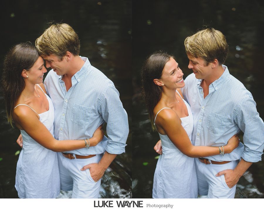 Couple embracing in water; woman in white dress, man in blue shirt, smiling.