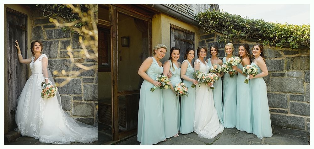 Bride with bridesmaids outdoors near a stone building. The bride wears white, bridesmaids in pale blue dresses.