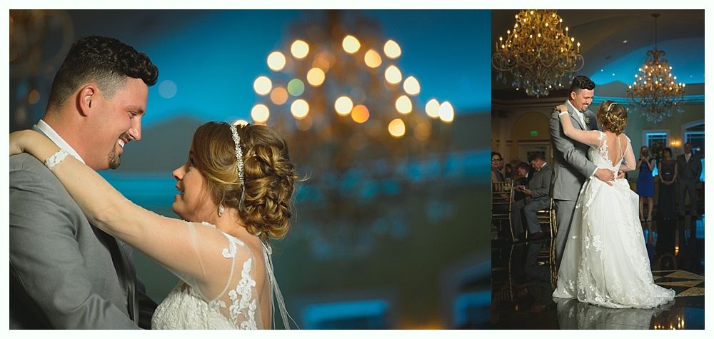 Newlyweds dance at their wedding reception. The bride in a white dress, the groom in a grey suit.