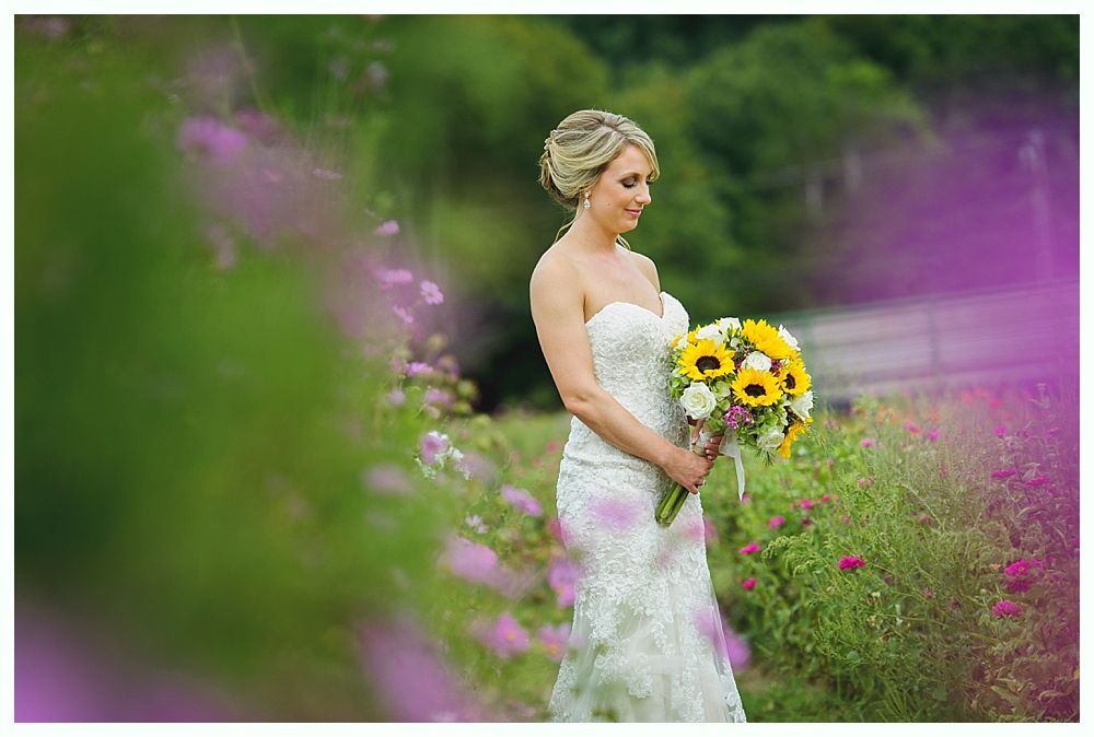 Wedding party walking down a road with bouquets raised. Black and white photo.