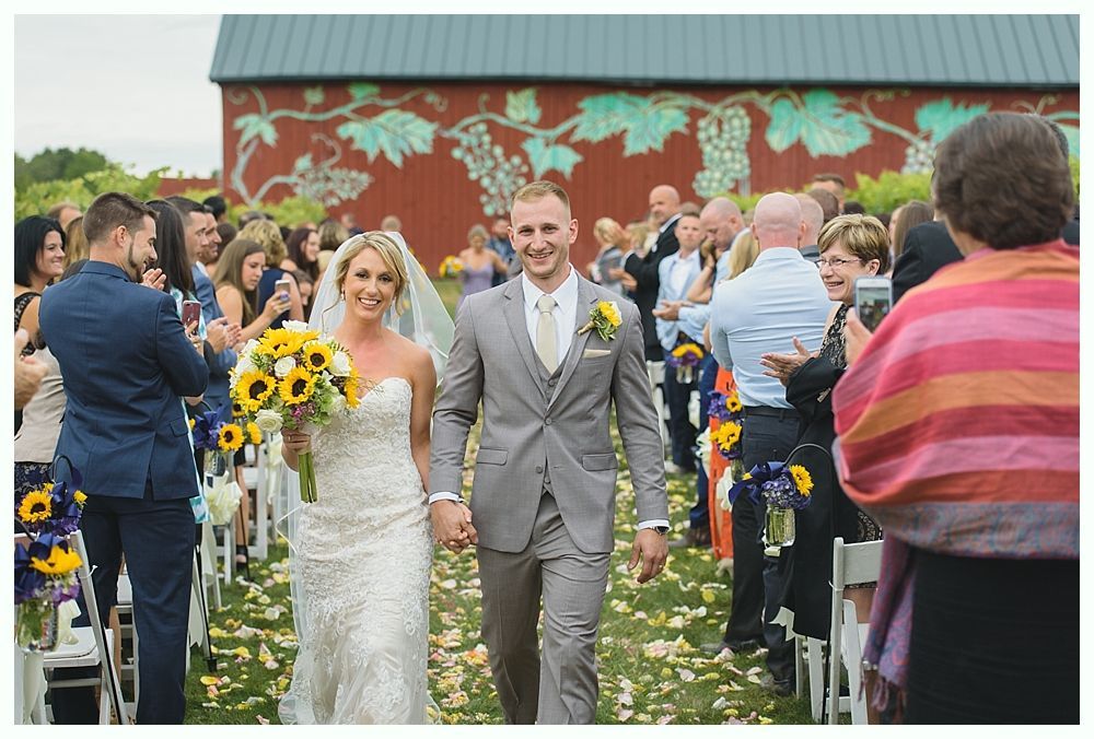 Wedding cake centerpiece with flowers; table setting with blue napkins and flowers.