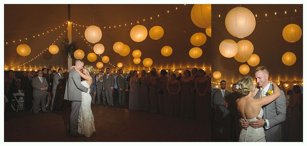 Guests at a wedding, one man smiling at the left, another man giving a speech in a room with blue lighting.