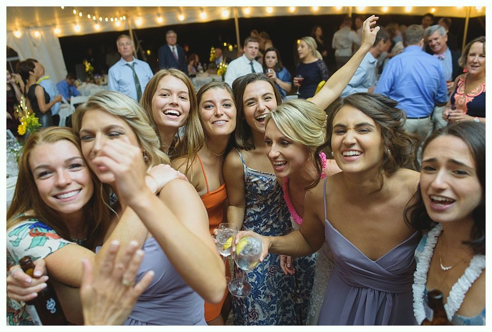 Newlyweds celebrate with champagne bottles, arms raised, in dark outdoor setting.