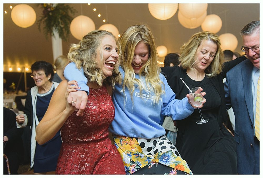 Three smiling people taking a selfie at a party under blue lights.